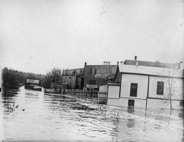 Buildings in high flood water, and floating near the powerhouse spillway.