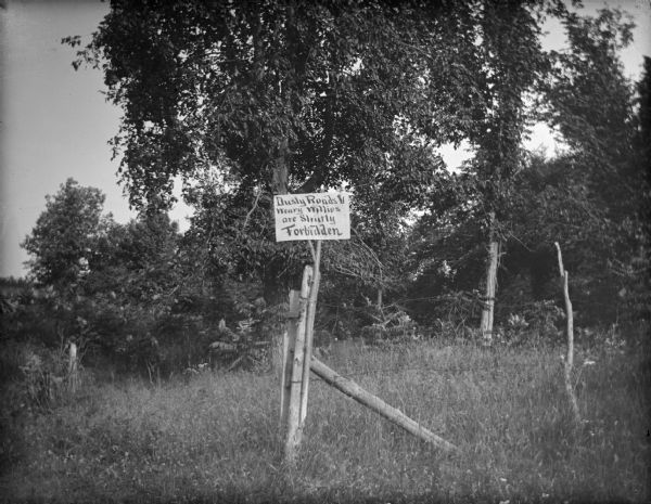 Fence and sign that says, "Dusty Roads and Weary Willies are Strictly Forbidden."