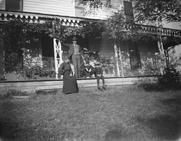 Man, woman, and two boys posing on a long porch.