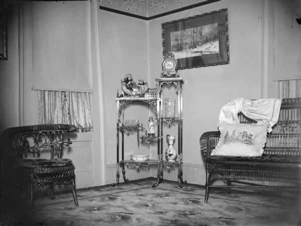 Interior of a parlor with a knickknack table and articles.