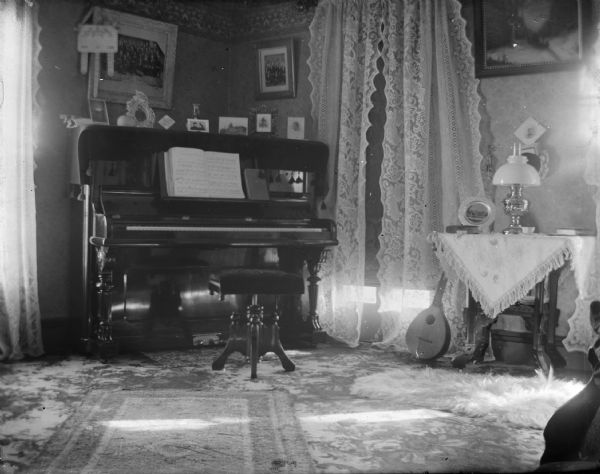 Interior of a parlor with piano and mandolin.