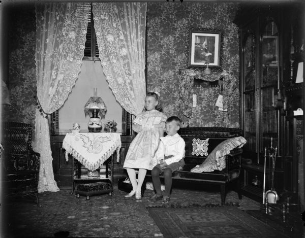 Two children posing in a parlor, probably Dudley and Marguerite Osborn inside the Spaulding House.