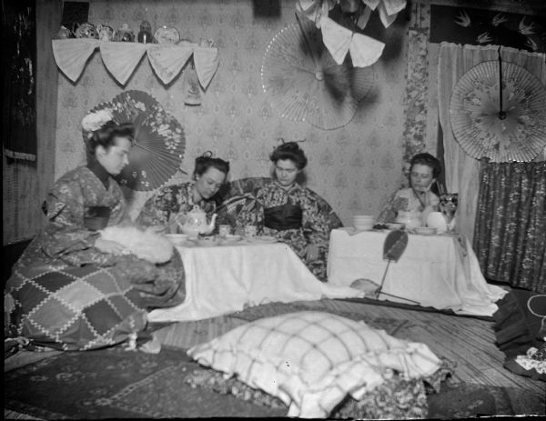 Four women wearing traditional Japanese dress having tea.