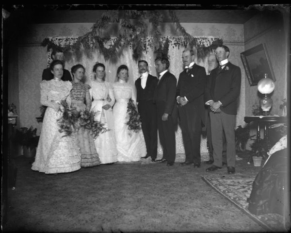 Bride, groom, and attendants posed standing at a wedding.