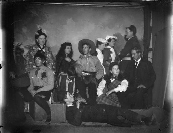 Studio portrait of five men and five women dressed in several different costumes.