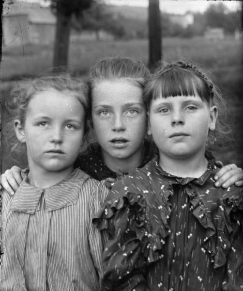 Portrait of three girls in a field.	
