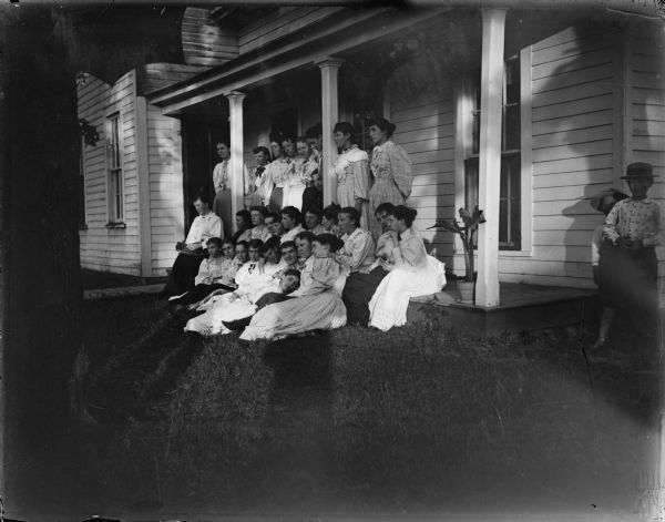 Large group of women posing on steps of a porch.