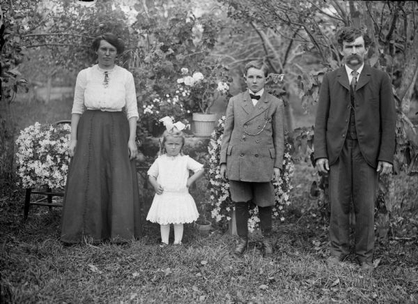 Man and woman with boy and girl posing outdoors.