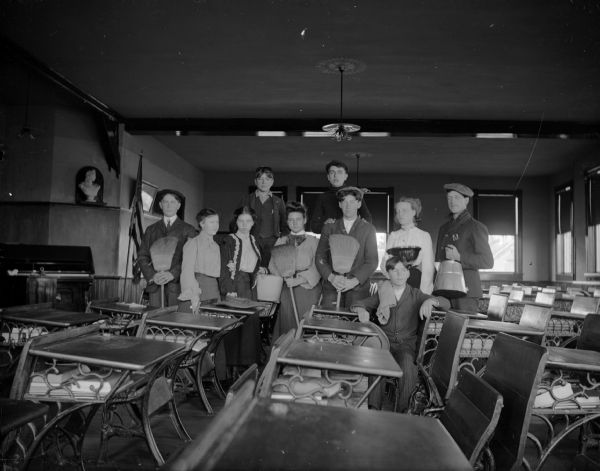 Students pose with cleaning equipment in a classroom, possibly in the old high school. The boy on far right may be Albert McDonald.