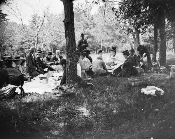 A large group of individuals gather to have a picnic.