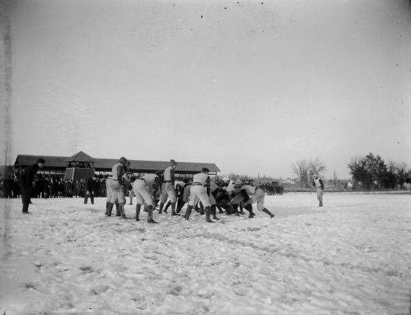 Winter scene with two teams line up on a snowy field during a football game at the Jackson County Fairgrounds.