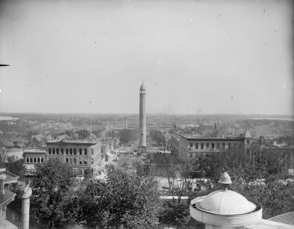 Elevated view, probably taken from the old Wisconsin State Capitol building, looking down East Washington Avenue toward the water tower.