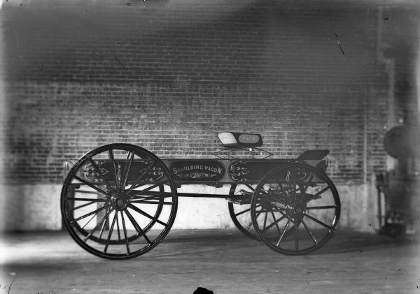 A Spaulding Wagon parked inside of a brick building, possibly the first Spaulding Wagon built in Black River Falls.	