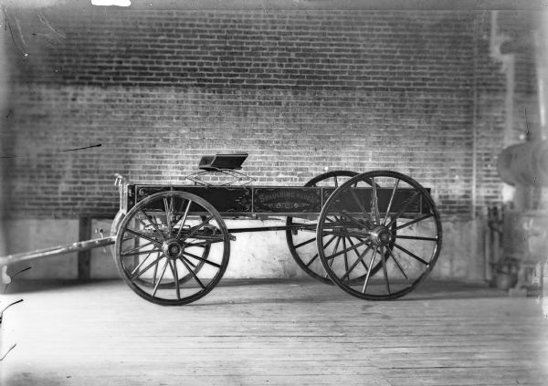 A decorative Spaulding wagon is parked inside a brick building.