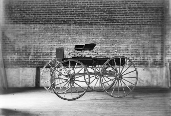 A Spaulding brand wagon is parked inside a brick building.