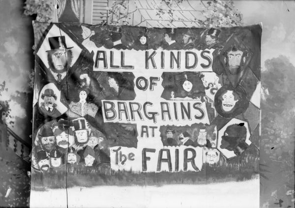 A studio portrait of a sign which is advertising "All Kinds of Bargains at the Fair" and is surrounded by drawings of men and women. A painted backdrop can be seen behind the sign.