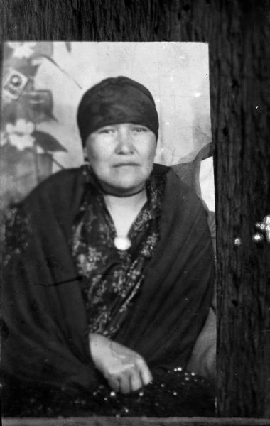 Copy photograph of a Ho-Chunk woman wrapped in a fringed shawl and wearing a head scarf, reportedly introduced by the Peyote women circa 1908. Identified as Kate White Otter.