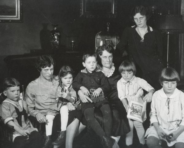 Group portrait of members of the Haydon, Brown and Shiverick families at the Brown home, 121 East Gilman Street. Tim Brown IV (center) is holding a toy train engine. There is a bird cage on top of the piano.

Left to right:  Robert M. Haydon, Jr., Eleanore Brown Haydon, Annie Brown Haydon, Timothy Brown IV, Annie Storer Brown, Ruth Ann Shiverick, Mary Storer Shiverick.