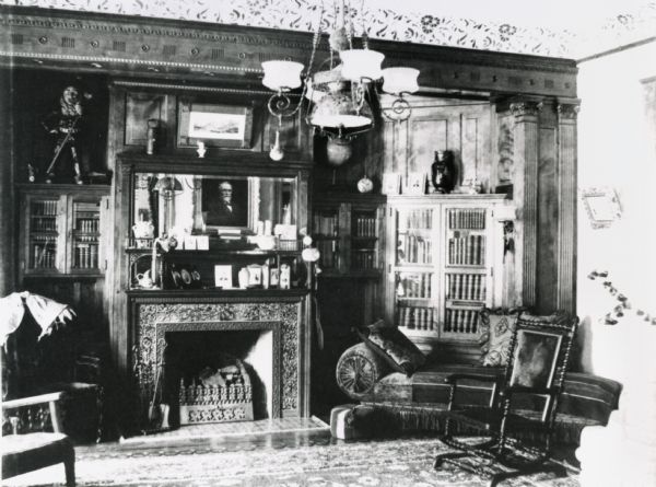 Fred and Annie Brown's living room, 121 East Gilman Street.  The photograph was made before the house had electricity, so the lights pictured are gas lights.  In the mirror is the reflection of a portrait of Timothy Brown II, Fred's father, which hangs over the piano on the other side of the room.