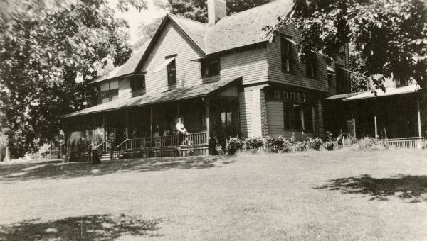 F.M. Brown and Annie S. Brown's summer cottage in Maple Bluff.  The address would now be 655 Farwell Street.  Annie S. Brown is sitting on the porch.