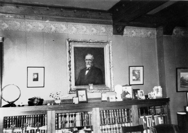 Part of Annie S. Brown's library room, 121 East Gilman Street.  The portrait on the wall is of Timothy Brown II (July 24, 1823-November 15, 1879), her husband, Fred Brown's father.