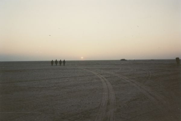 Scene in the Saudi Arabian desert during the Persian Gulf War.  Soldiers are visible in the distance.
