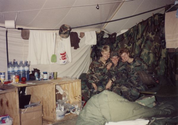 Three soldiers in tent in Saudi Arabia during the Persian Gulf War.