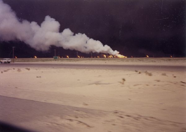 View of burning oil wells in the desert during the Persian Gulf War.
