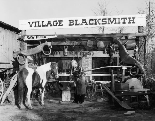 Village Blacksmith at work with horse in Pioneer Village.