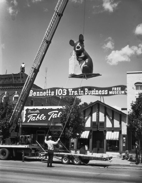 Large mouse being lifted by crane onto Bennett's Table Talk at 211-213 Broadway.