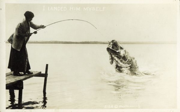 Photomontage of a woman reeling in a huge fish. The woman, wearing a skirt, is standing on a dock overlooking a lake. White text in the upper middle portion of the image field says, "I Landed Him Myself."