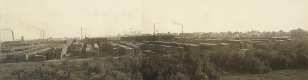 Panoramic view of lumber yards and sawmills. Telephone poles have been touched out in lower left of foreground.