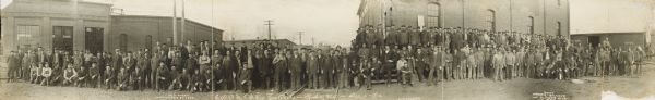 Panoramic group portrait of Chicago, St. Paul, Minneapolis and Omaha Railroad shopworkers. Text at the bottom image identifies, "W.H. Thorn - Master Car Builder," and "E.J. Lombard - Gen. Foreman."