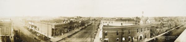 Panoramic bird's-eye view. Identifiable businesses include: T.J. McNally Clothing & Shoes, M.J. Casey, The Winter Drug Store, Bank of New Richmond.