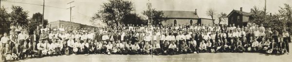 Panoramic view of enlisted men from district no. 2, readying to depart for Camp Taylor. Most are wearing suits and ties, and holding hats.  The Dun Clothing Co. visible in the background.