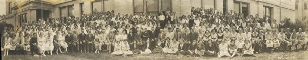 Panoramic group portrait of female and male students attending summer school at the Platteville State Normal School. Inscription at the bottom reads, "Professor Edgar Riley, Director."