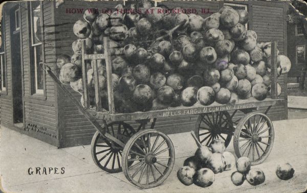 Photomontage of a stack of giant grapes resting on a flatbed cart.  The side of the cart bears the inscription, "Wells Fargo Company Express."  Red text at the top reads, "How we do things at Rockford, Ill."