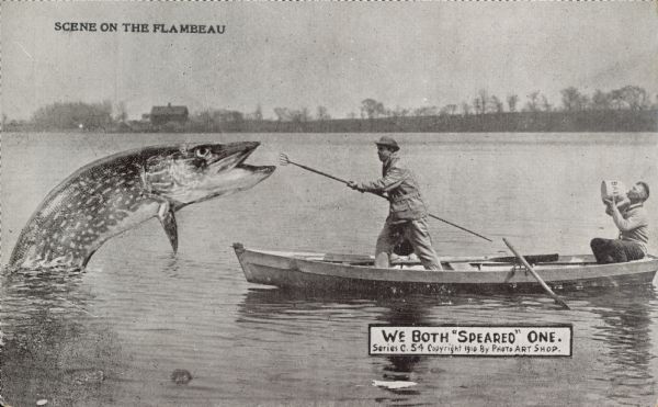 Photomontage of two men in a rowboat, one of whom is attempting to spear a giant fish with a forked spear, while the other is drinking out of a jug labeled, "Bait."  Caption at the top reads, "Scene on the Flambeau."  A text box in the lower right corner says, "We Both 'Speared' One.  Series C.54."  As with most of Erickson's work, this postcard is credited to his studio, "Photo Art Shop."