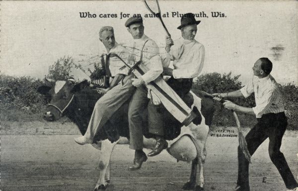 Three men ride a dairy cow on a dirt road, while a fourth pulls at the cow's tail. Of the three men, one is holding a tennis racket, one is holding a golf bag, and one has a camera in his lap. Text at the top of the image reads, "Who cares for an auto at Plymouth, Wis."
