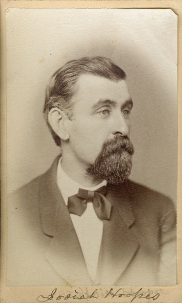 Carte-de-visite portrait of Josiah Hoopes (b. 1832, death date unknown), American botanist. In 1853, he established a tree nursery in West Chester, which is now the one of the largest in the country.  He was a founder and seven-year president of the Horticultural Association of Pennsylvania. His treatise "Book of Evergreens," is considered to be the standard for the subject. Seen here wearing a bow tie, sitting in three-quarter profile. Handwritten inscription at the bottom reads, "Josiah Hoopes."