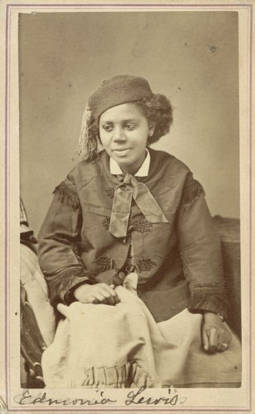 Carte-de-visite portrait of Edmonia Lewis (1845-1890), African American Sculptor. Lewis, the first famous American sculptor of African descent, had a Chippewa mother and a free black father. After being orphaned at age twelve, she was adopted by abolitionist parents and eventually developed into an accomplished Neo-classical sculptor. While in Rome, she worked and exhibited with the likes of Harriet Hosmer. Handwritten inscription at bottom of card reads, "Edmonia Lewis."