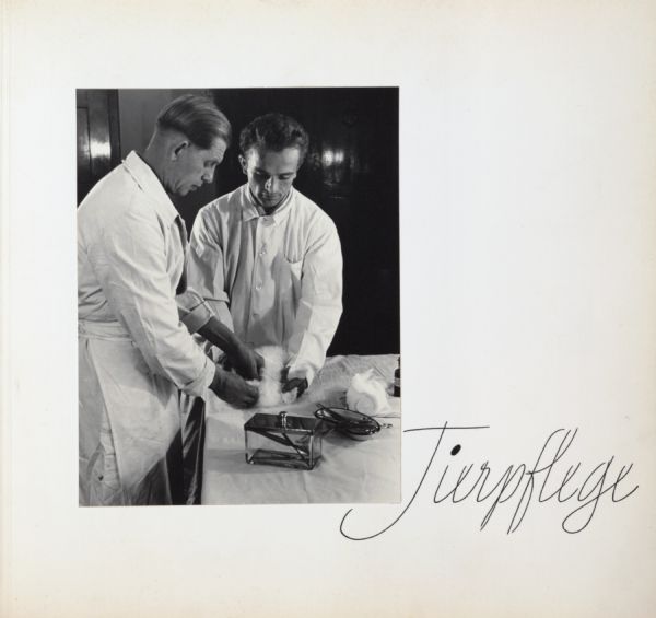 Two animal keepers caring for angora rabbit on examination table and medical instruments. Text on the page says, "Tierpflege".