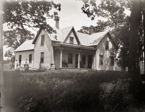 The home of the Burlingames, possibly belonging either to the parents of Ada Bass or her brother Everett. There is someone outside near the side door.