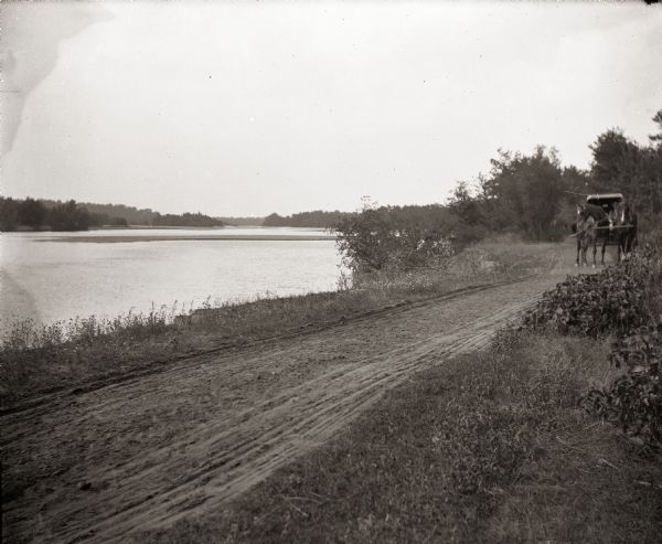 Horse and carriage traveling on dirt road along the Wisconsin River.