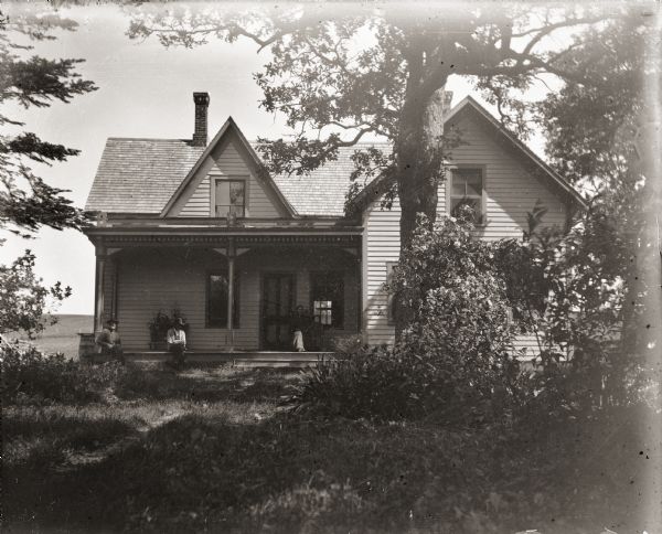 Family on the front porch of the Burlingame house, possibly belonging either to the parents of Ada Bass or her brother Everett.