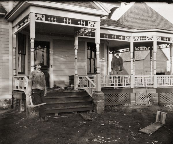 Two carpenters pose on the front porch of the Bass family home at 207 Clay Street in the fall of 1897.  The Gibbs Brothers, of Packwaukee, were the architects and builders of the house.