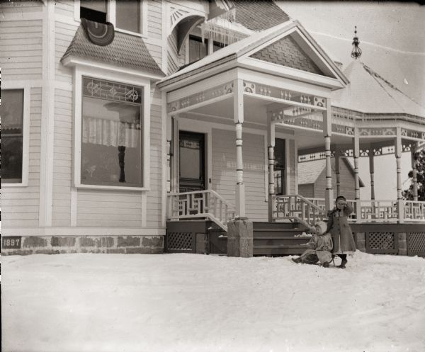 Everetta and Cary Bass on sleigh in front of the Bass family home, 207 Clay Street.