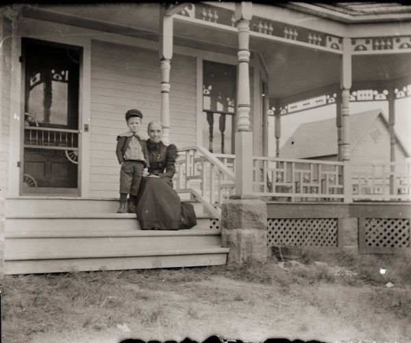 Cary Bass and his paternal grandmother, Mrs. M. Lorinda Bass, sitting on the front porch of the Bass family home at 207 Clay Street.