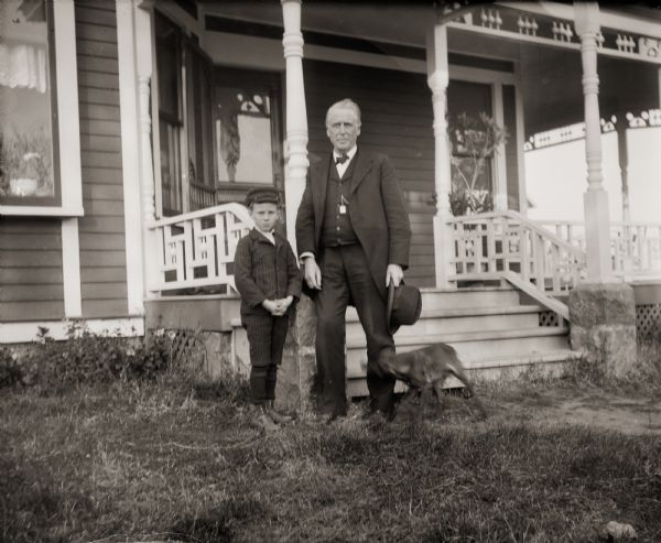 Cary Bass, his Great Uncle Cary, and a dog, posing in front of the Bass family home, 207 Clay Street.