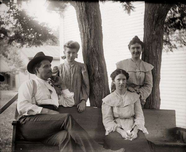 Kern Family posing on a bench under a tree behind the Methodist church.